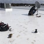 tradesperson installing roof equipment commercial pvc roof